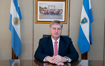 Url: Foto del Gobernador de La Pampa en su despacho junto a la Bandera Nacional y la Bandera de La Pampa