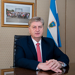 Img: Sergio Zilioto sentado en su escritorio junto a la bandera Provincial